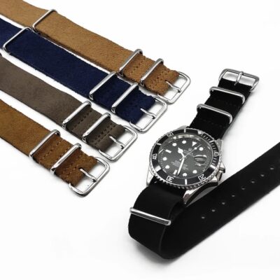 Multiple color options of Soft Suede NATO Straps displayed on Rolex Submariner wristwatch, showcasing navy blue, brown, grey, khaki, and black shades.