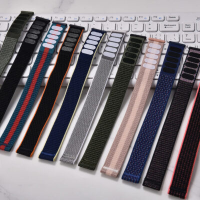 Assortment of NATO style nylon watch bands with quick release spring bars and velcro closure displayed on a desk.