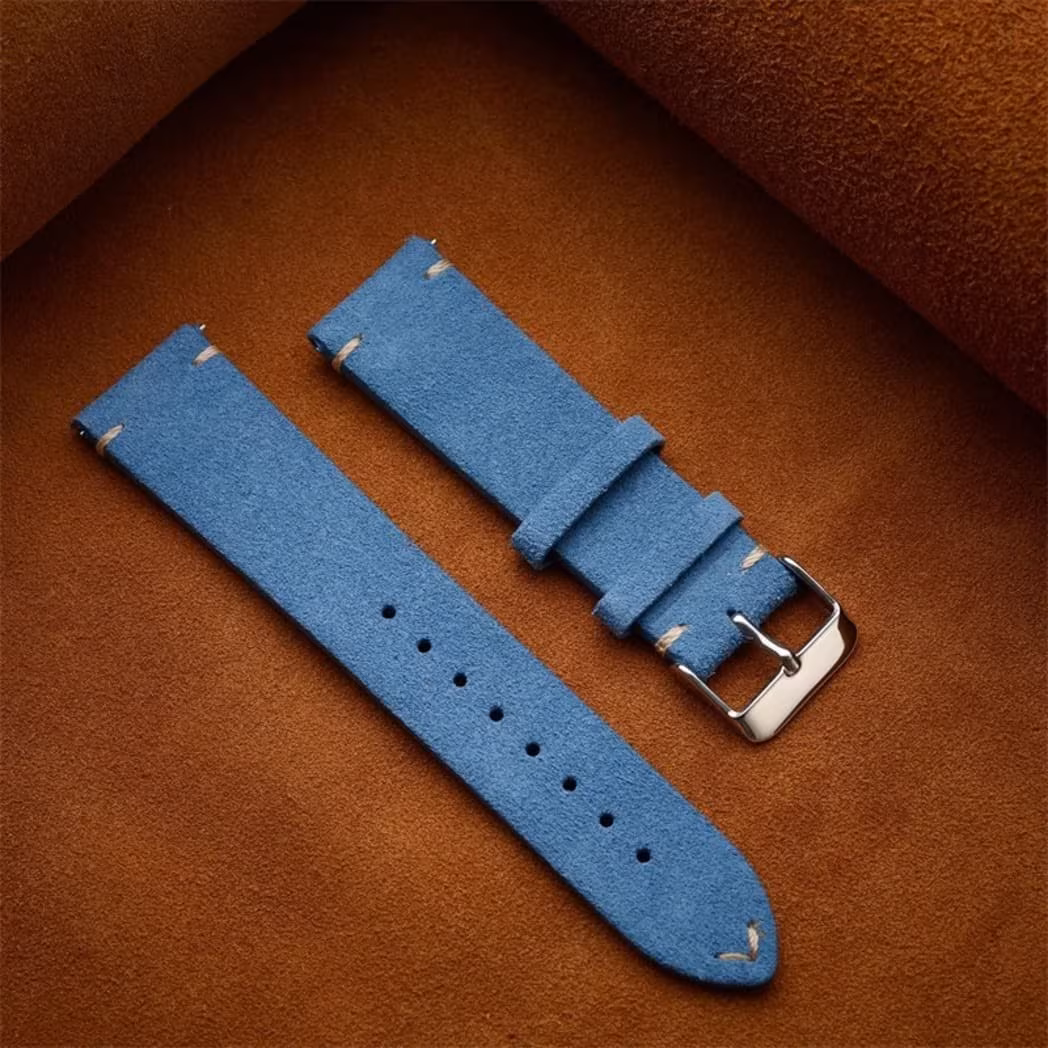 Vintage Calfskin Suede Watch Strap - (14, 16, 18, 19, 20, 21, 22mm) 15 Two-piece mid-blue vintage suede watch strap laid flat on a brown leather background, showing the adjustment holes and silver buckle.