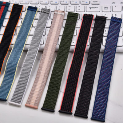 Collection of NATO style nylon watch bands with quick release spring bars and velcro closure displayed on a desk.