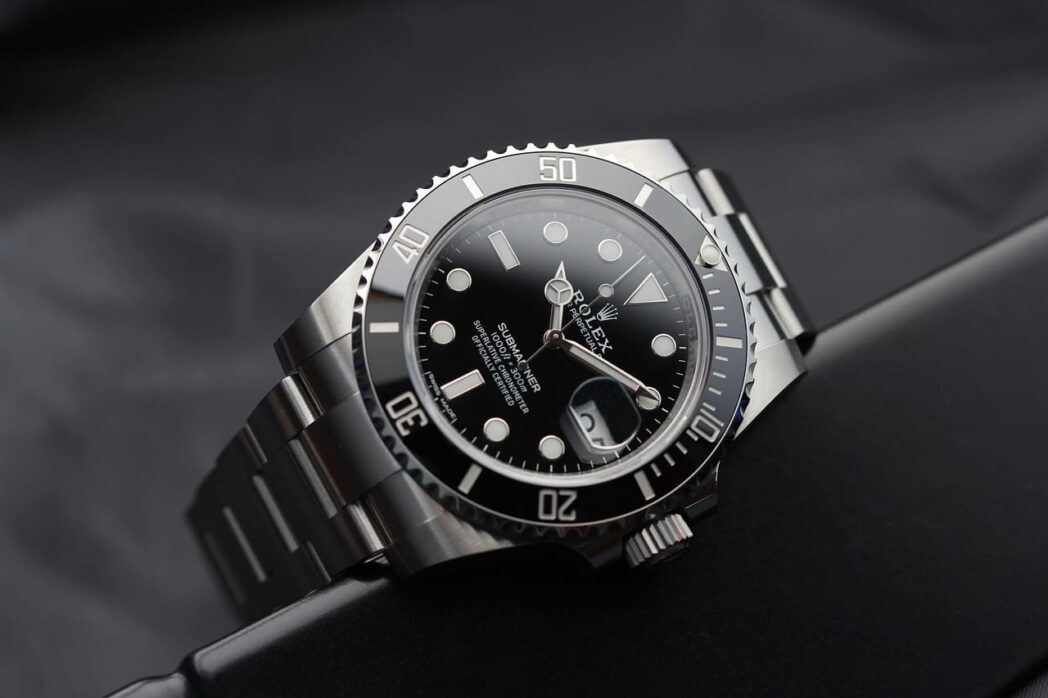 Rolex Submariner watch with black dial and bezel displayed on its iconic steel Oyster bracelet.